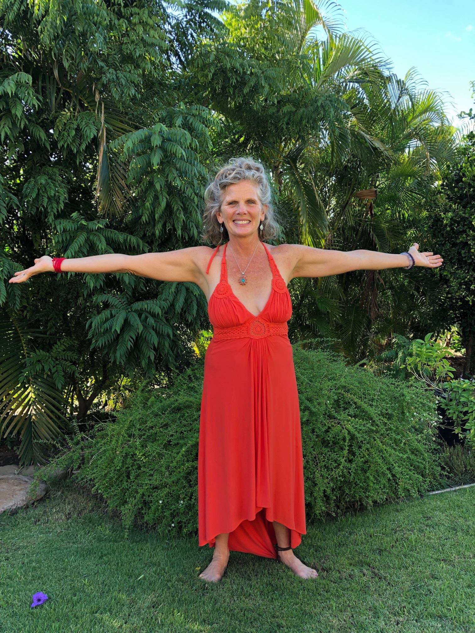 Neesa Mills in a red dress with her arms outstretched