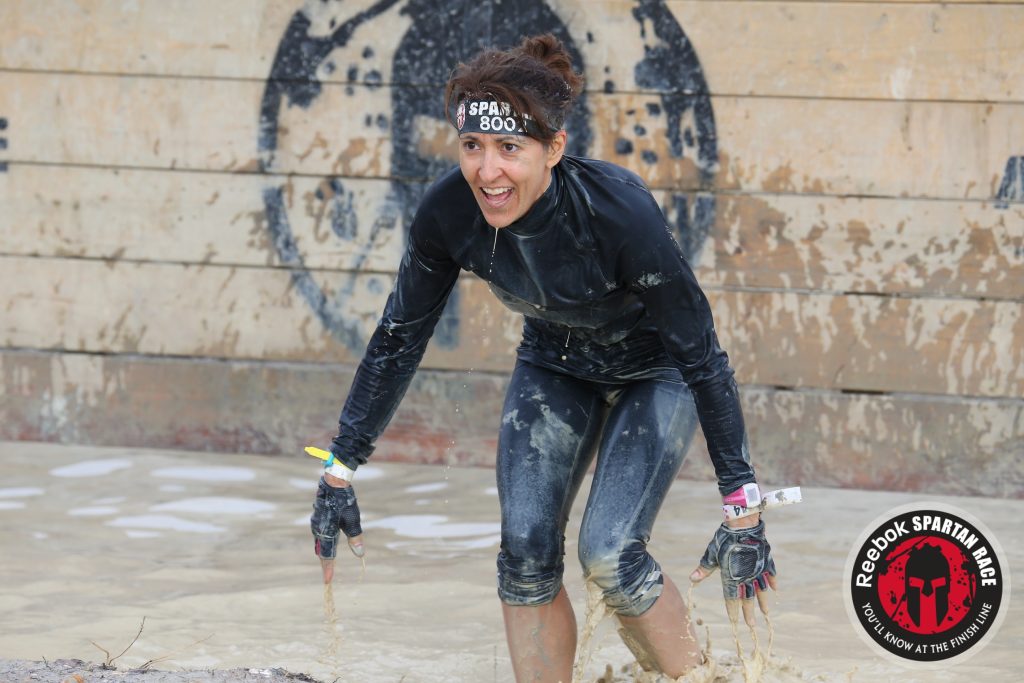Coach Joan Jakel competing in a Spartan Race showing her resilient warrior spirit